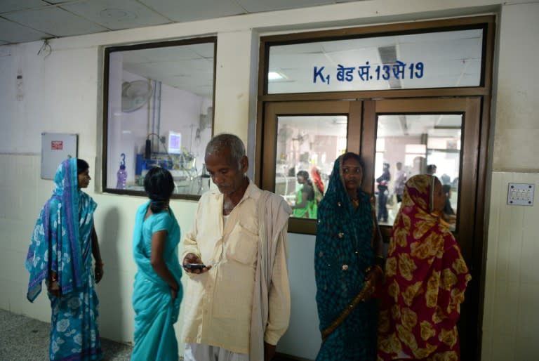 This file photo taken on August 14, 2017 shows Indian relatives of patients waiting outside the encephalitis ward at the Baba Raghav Das Hospital in Gorakhpur in the northern Indian state of Uttar Pradesh