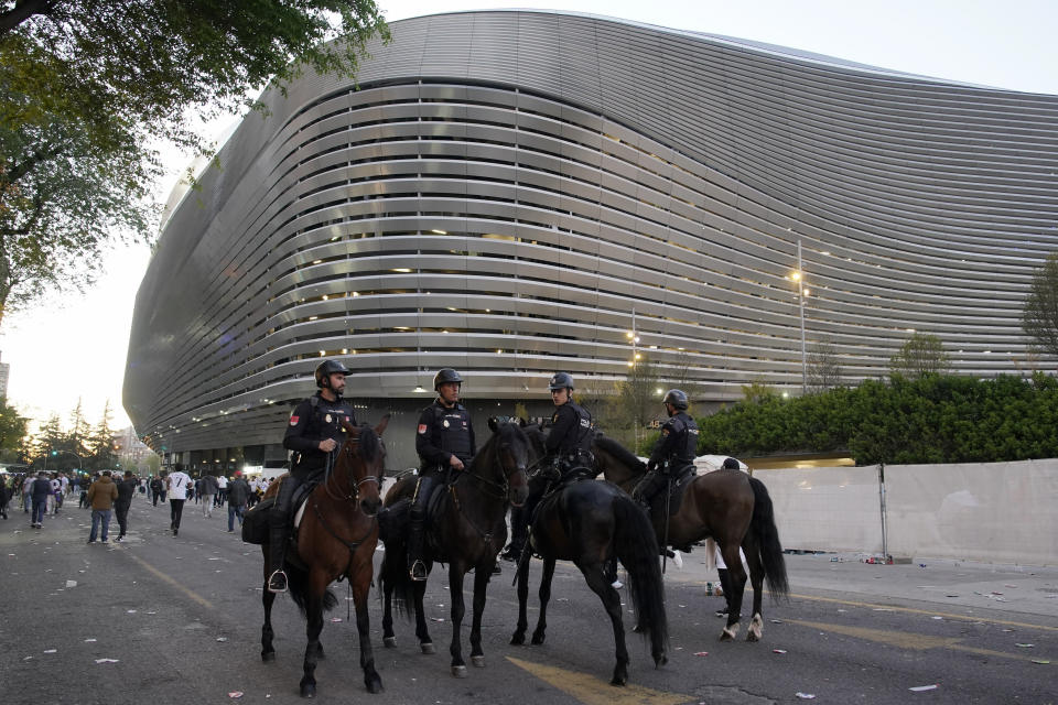 Police officers ride horses outside the Santiago Bernabeu stadium, ahead of the Champions League quarterfinal first leg soccer match between Real Madrid and Manchester City in Madrid, Spain, Tuesday, April 9, 2024. This week's Champions League soccer games will go ahead as scheduled despite an Islamic State terror threat. A media outlet linked to the terror group has issued multiple posts calling for attacks at the stadiums hosting quarterfinal matches in Paris, Madrid and London. (AP Photo/Andrea Comas)