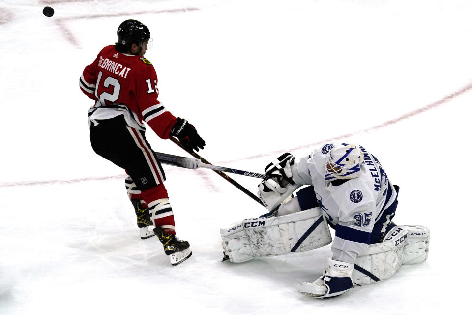 Tampa Bay Lightning goalie Curtis McElhinney, right, blocks a shot by Chicago Blackhawks' Alex DeBrincat during the second period of an NHL hockey game in Chicago, Friday, March 5, 2021. (AP Photo/Nam Y. Huh)