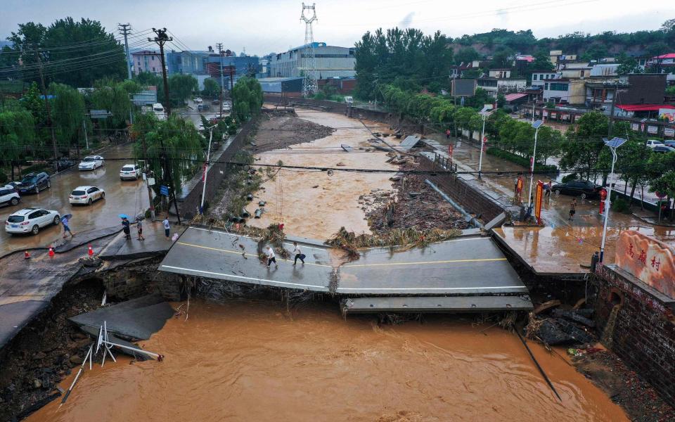 This aerial photo taken on July 21, 2021 show a damaged bridge following heavy rains which caused severe flooding in Gongyi in China's central Henan province. (Photo by STR / AFP) / China OUT (Photo by STR/AFP via Getty Images) - Why China will remain silent on climate change despite heaviest rain in a millennium /AFP 