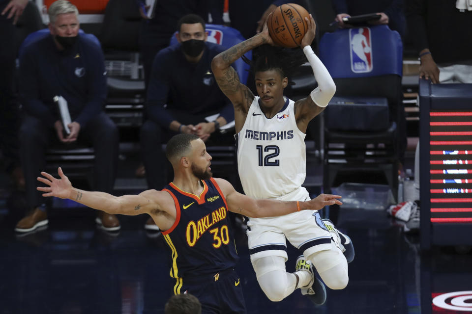 Memphis Grizzlies' Ja Morant, right, passes against Golden State Warriors' Stephen Curry during the second half of an NBA basketball Western Conference play-in game in San Francisco, Friday, May 21, 2021. (AP Photo/Jed Jacobsohn)