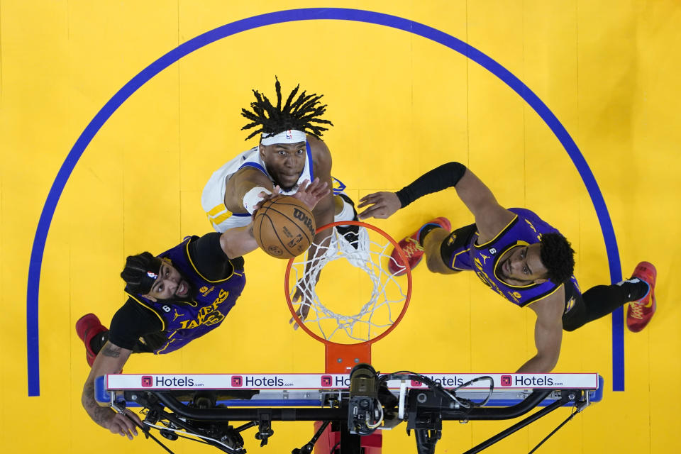 Golden State Warriors forward Kevon Looney, center, and Los Angeles Lakers forward Anthony Davis, left, jump for the ball during the second half of Game 2 of an NBA basketball Western Conference semifinal game, Thursday, May 4, 2023, in San Francisco. (AP Photo/Godofredo A. Vásquez)
