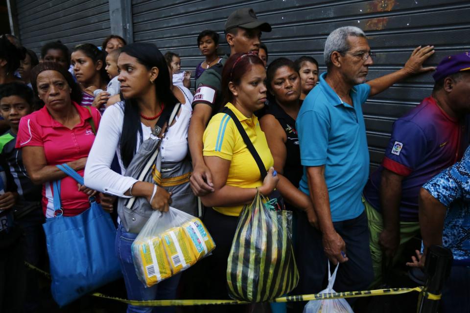 People line up to buy toilet paper and baby diapers at a supermarket in downtown Caracas January 19, 2015. There's a booming new profession in Venezuela: standing in line. The job usually involves starting before dawn, enduring long hours under the Caribbean sun, dodging or bribing police, and then selling a coveted spot at the front of huge shopping lines. As Venezuela's ailing economy spawns unprecedented shortages of basic goods, panic-buying and a rush to snap up subsidized food, demand is high and the pay is reasonable. Picture taken January 19, 2015. REUTERS/Jorge Silva (VENEZUELA - Tags: POLITICS BUSINESS SOCIETY)