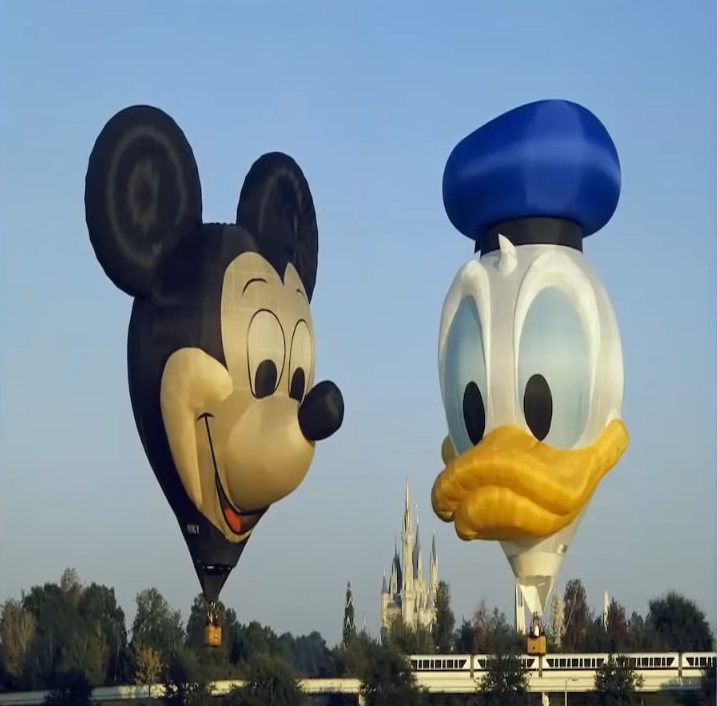 Mickey Mouse and Donald Duck hot air balloons are flying over Disneyland