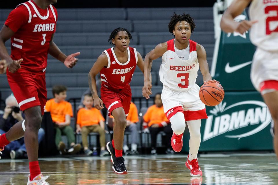 Flint Beecher guard Jacoby Holliday Jr. dribbles against Ecorse guard Malik Olafioye, left, during the second half of Beecher's 64-53 win in the Division 3 semifinal at Breslin Center on Thursday, March 23, 2023.