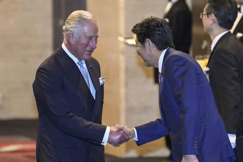 英國查爾斯王子參加日本德仁天皇登基儀式，與日本首相安倍晉三握手。（AP）