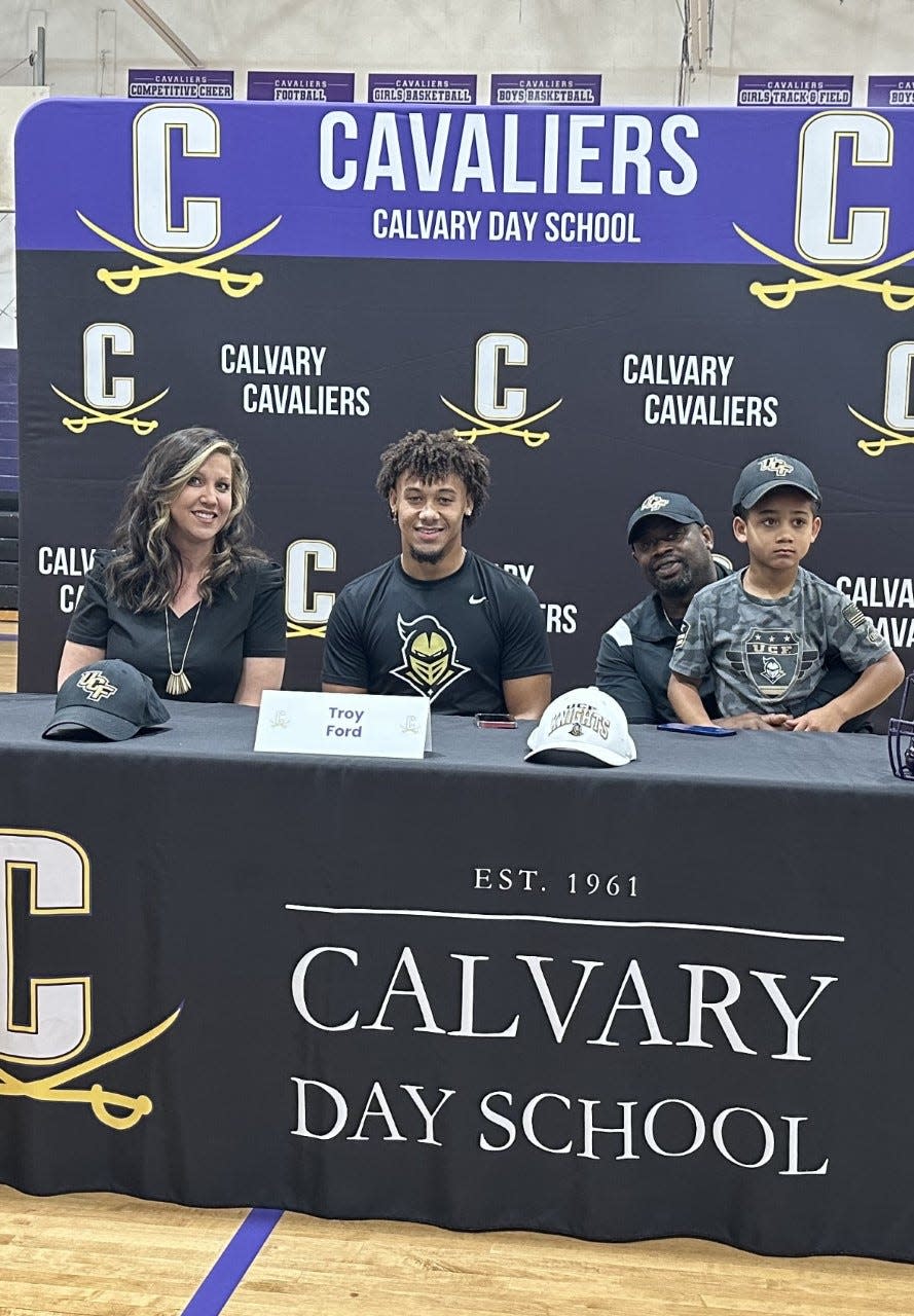 Troy Ford Jr. of Calvary Day, with his family, as he signed to play at UCF on Wednesday.