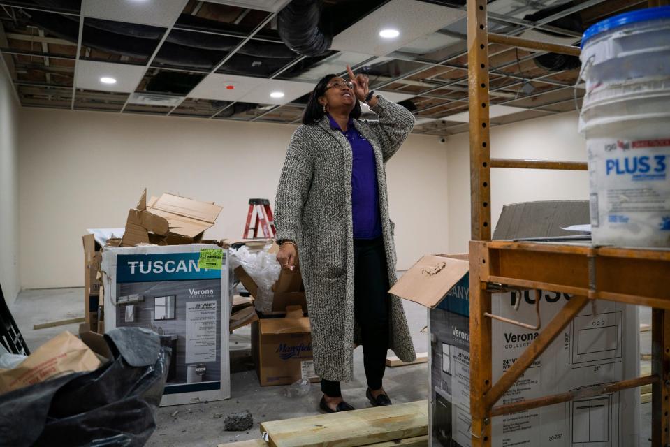 Betty Henderson, 51, reacts after noticing ceiling fixtures have been installed at her new building undergoing construction in Detroit on Jan. 19, 2023. During the summer, the building that Henderson was hoping to renovate in order to expand her current child care facility, caught on fire and was destroyed. Now, Henderson restarts the renovation process.