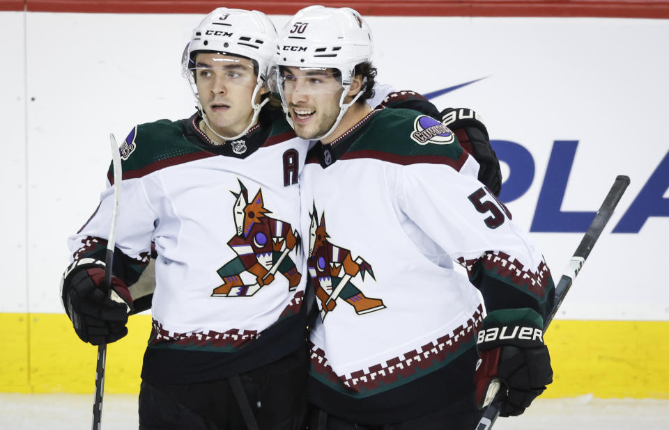 Arizona Coyotes defenseman Sean Durzi (50) celebrates his goal with teammate forward Clayton Keller (9) during the second period of an NHL hockey game against the Calgary Flames, Tuesday, Jan. 16, 2024 in Calgary, Alberta. (Jeff McIntosh/The Canadian Press via AP)