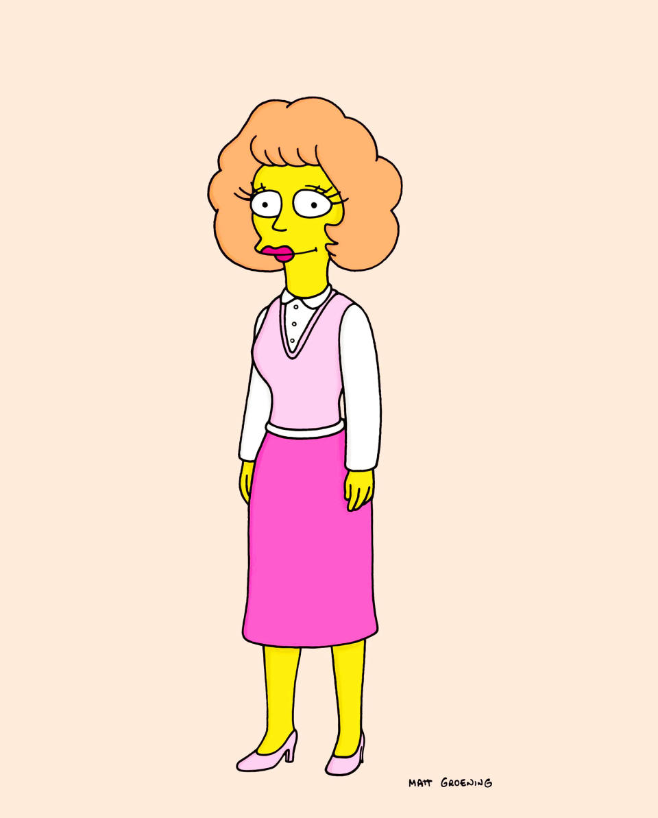 Maude Flounders from The Simpsons wearing a blouse, vest, and skirt. She has curly hair and is standing
