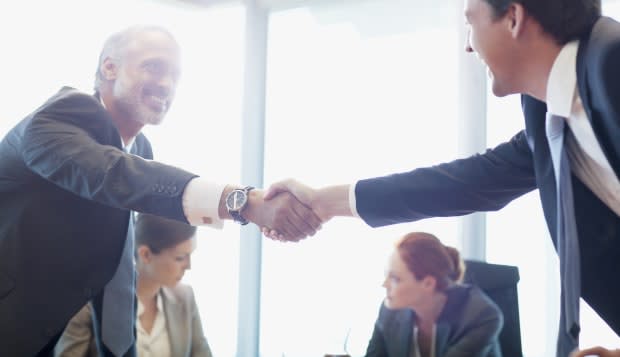 Businessmen shaking hands in conference room