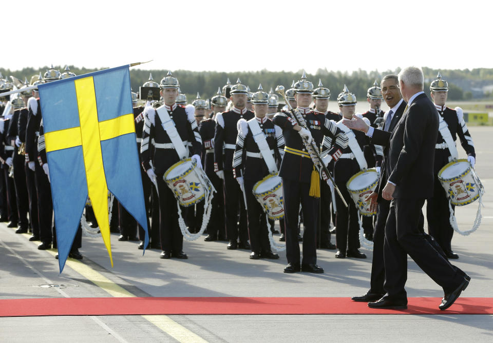 CORRECTS THE IDENTITY OF THE PERSON ACCOMPANYING OBAMA U.S. President Barack Obama walks with Sweden's Foreign Minister Carl Bildt, right, past members of the Royal Life Guards: Honorary Guard and Colour Guard, during the arrival ceremony at Stockholm-Arlanda International Airport, Wednesday, Sept. 4, 2013, in Stockholm, Sweden. (AP Photo/Pablo Martinez Monsivais)