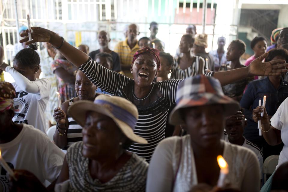 In this Dec. 13, 2018 photo, Makileine Derosier cries out for justice during a memorial ceremony for the victims of the La Saline massacre in Port-au-Prince, Haiti. Derosier, who works as a street vendor, said the attackers stole her day's earnings on the day of the massacre, and that her cousin Lasib died while she hid in a bathroom and managed to escape after dark. (AP Photo/Dieu Nalio Chery)