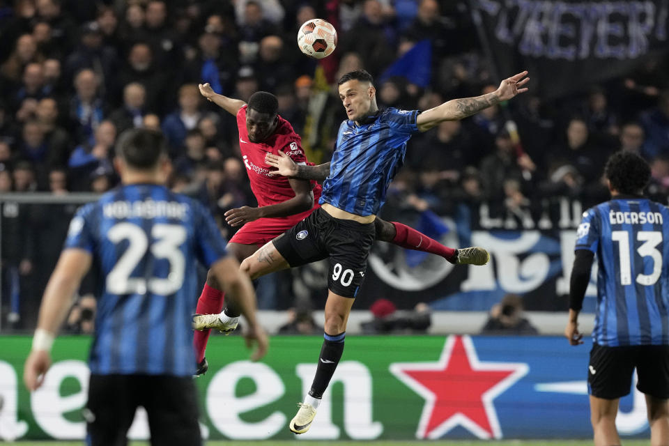 Liverpool's Ibrahima Konate, center left, jumps for the ball with Atalanta's Gianluca Scamacca during the Europa League quarterfinal, second leg, soccer match between Atalanta and Liverpool at the Stadio di Bergamo, in Bergamo, Italy, Thursday, April 18, 2024. (AP Photo/Antonio Calanni)