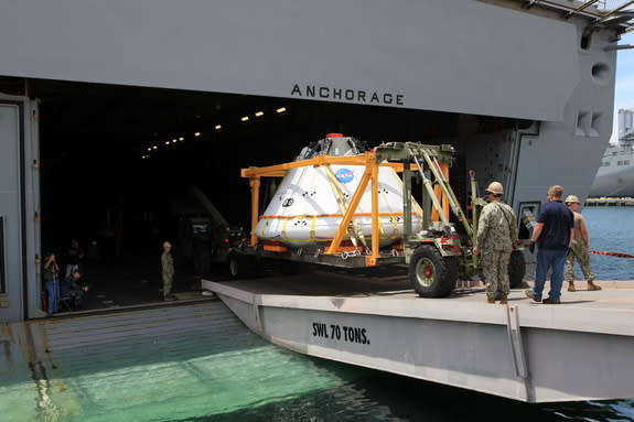 Caption: The Orion boilerplate test vehicle is loaded onto the USS Anchorage at the U.S. Naval Base in San Diego, California on July 29. A team of NASA engineers and U.S. Navy personnel will test out different techniques to haul the test spacec