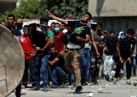 A Palestinian protester hurls stones towards Israeli troops during clashes in the West Bank village of Beita, near Nablus May 12, 2017. REUTERS/Mohamad Torokman