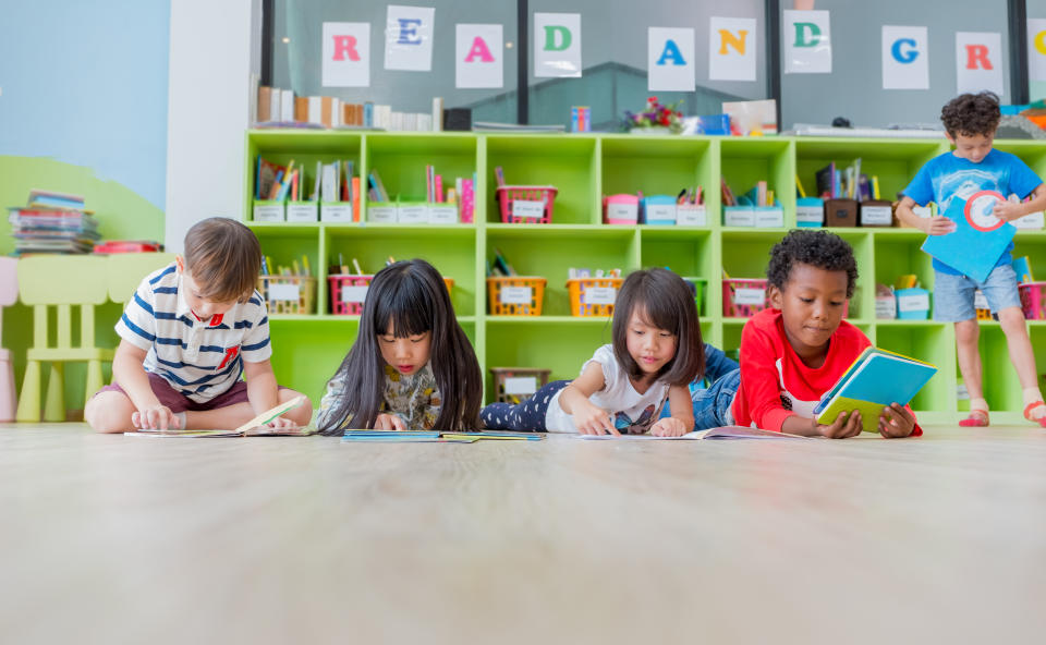 Group of diversity kid lay down on floor and reading tale book in preschool library,Kindergarten school education concept.