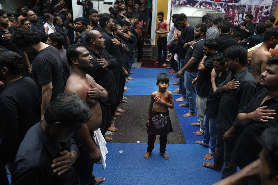 A Shiite Muslim boy stands between rows of adults beating their chests as they participate in a procession to mark Ashoura in Hyderabad, India, Saturday, July 29, 2023. Ashoura is the tenth day of Muharram, the first month of the Islamic calendar, observed around the world in remembrance of the martyrdom of Imam Hussein, the grandson of Prophet Mohammed. (AP Photo/Mahesh Kumar A.)
