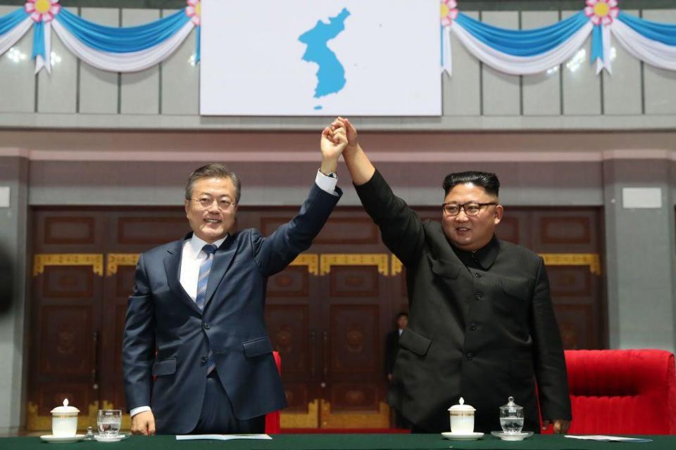 Moon Jae-in y Kim Jong-un con los brazos unidos en alto