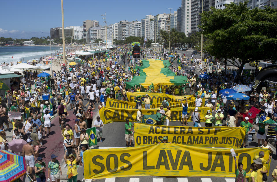 FILE - In this March 26, 2017 file photo, people march against corruption and in support of the "Car Wash" investigation on Copacabana beach, in Rio de Janeiro, Brazil. "Operation Car Wash" began in March 2014 as an investigation into money laundering involving a gas station owner in the southwestern state of Parana. The suspects reached plea bargains that opened windows onto an immense graft scheme.(AP Photo/Silvia Izquierdo, File)