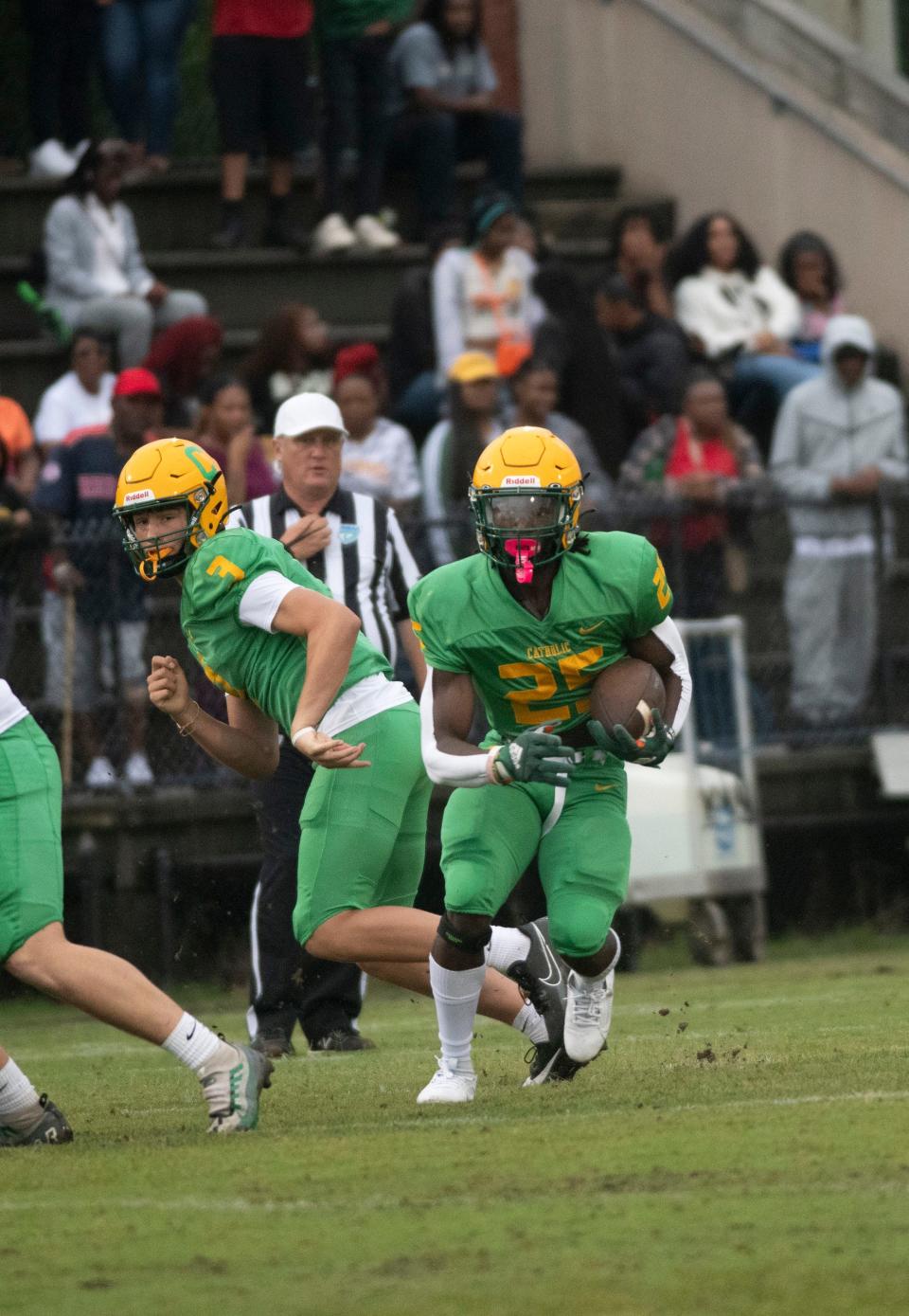 Catholic's CJ Nettles (No. 25) takes the handoff from Ryan Huff (No. 3) on the option play during Wednesday's Spring football game against Pine Forest. 