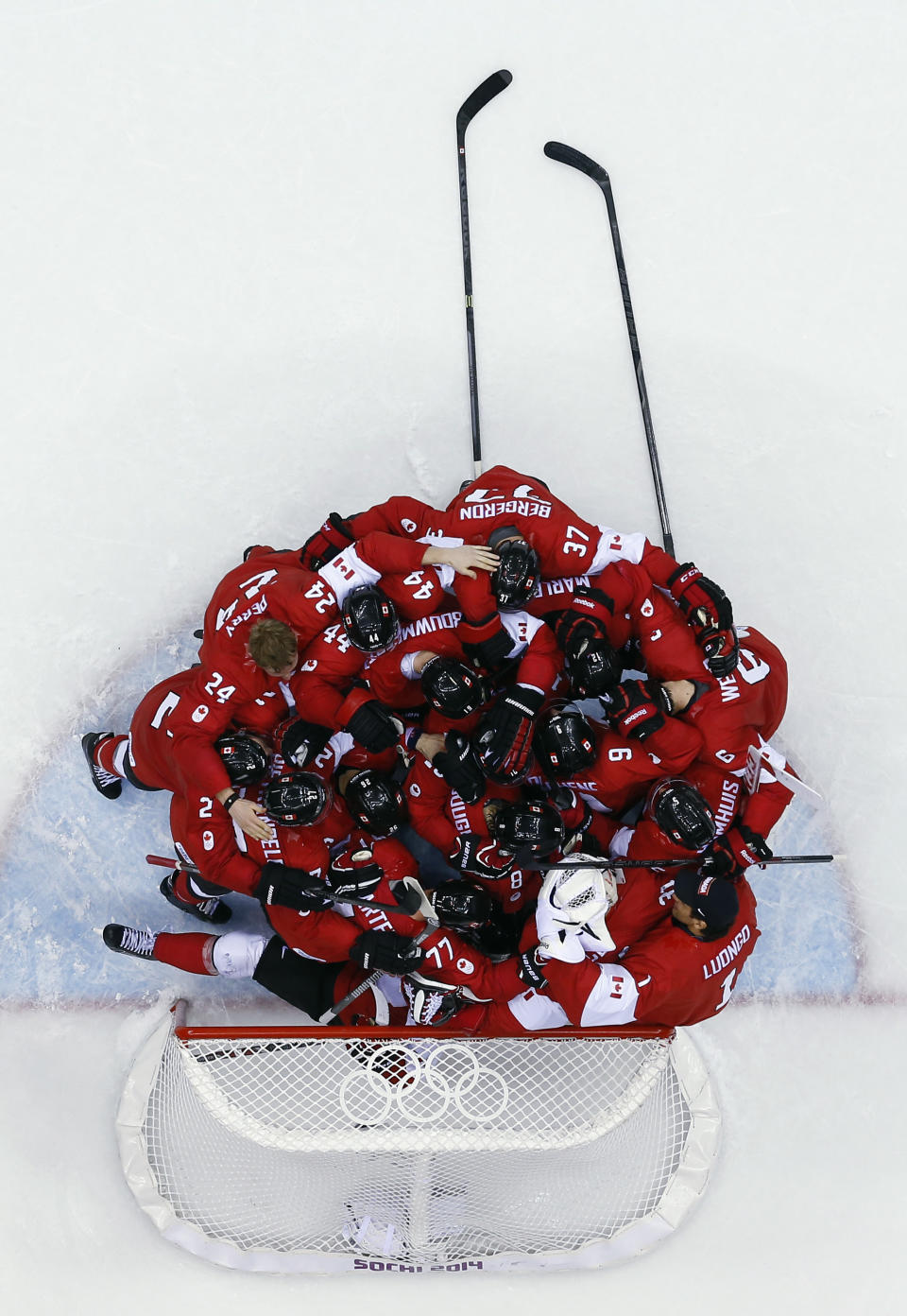 Canada goaltender Carey Price is swarmed by teammates as they celebrate after the men's gold medal ice hockey game against Sweden at the 2014 Winter Olympics, Sunday, Feb. 23, 2014, in Sochi, Russia. Canada won 3-0 to win the gold medal. (AP Photo/David J. Phillip )