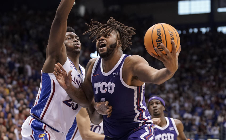 TCU center Eddie Lampkin Jr. (4) works his way inside against Kansas center Ernest Udeh Jr. (23) during the second half of an NCAA college basketball game on Saturday, Jan. 21, 2023, at Allen Fieldhouse in Lawrence, Kan. TCU defeated Kansas, 83-60. (AP Photo/Nick Krug)