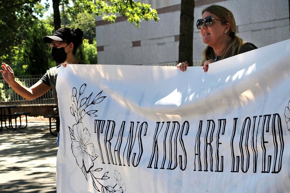 Heather Redding, left, and Elizabeth Waugh, of Orange County, North Carolina, rally for transgender rights outside the state Legislative Building in Raleigh, N.C., Wednesday, Aug. 16, 2023. North Carolina Republicans will attempt Wednesday to override the Democratic governor's veto of legislation banning gender-affirming health care for minors.