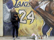 A man pays respects at a mural of Kobe Bryant in an alley in downtown Los Angeles after word of the Lakers star's death in a helicopter crash, Sunday, Jan. 26, 2020. (AP Photo/Matt Hartman)