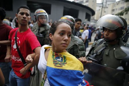 Opposition students march next to national guards during a march against President Nicolas Maduro's government in Caracas February 12, 2015. Reuters/Jorge Silva