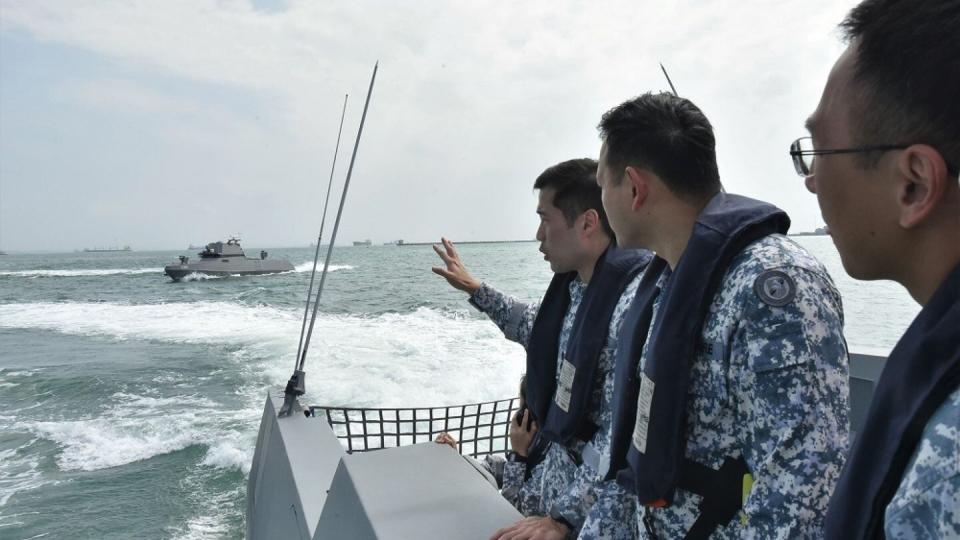 Lt. Col. Tan Kailing, left, who leads Singapore’s unmanned surface vessel squadron, provides a brief on maritime security capabilities. (Singaporean Defence Ministry)