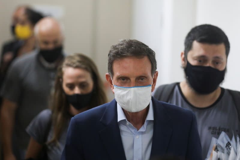 Rio de Janeiro's Mayor Marcelo Crivella is escorted by police officers after being detained