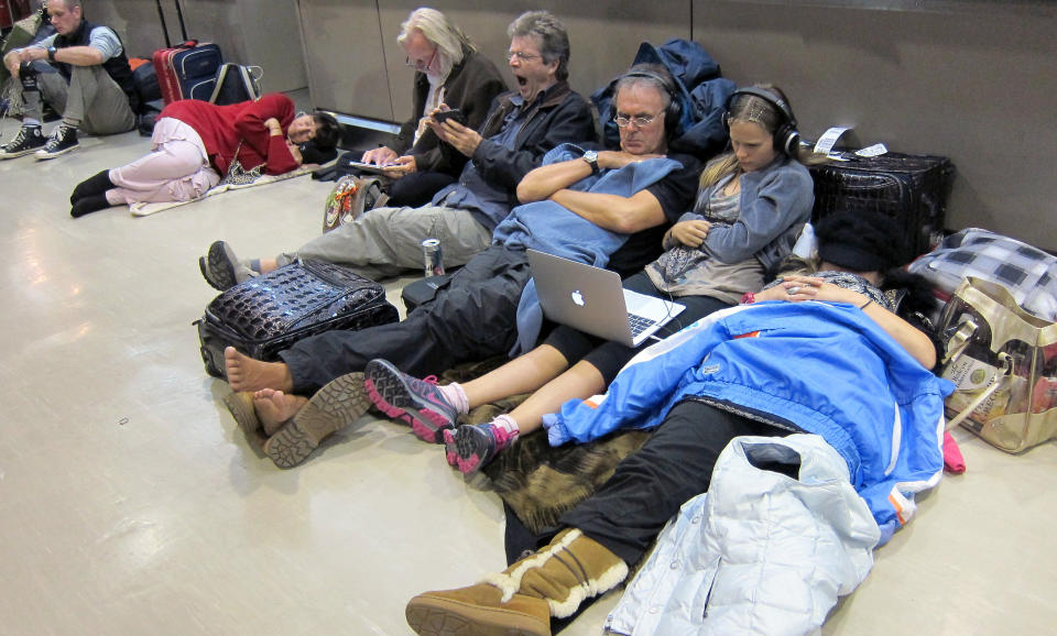 Passengers sit and sleep on the floor as they wait for flights, many of which were delayed or canceled due to heavy snowfall, at Narita International Airport, outside of Tokyo, Tuesday, Jan 15, 2013. This winter's first snow in the Tokyo area severely disrupted travel. (AP Photo Nick Ut)