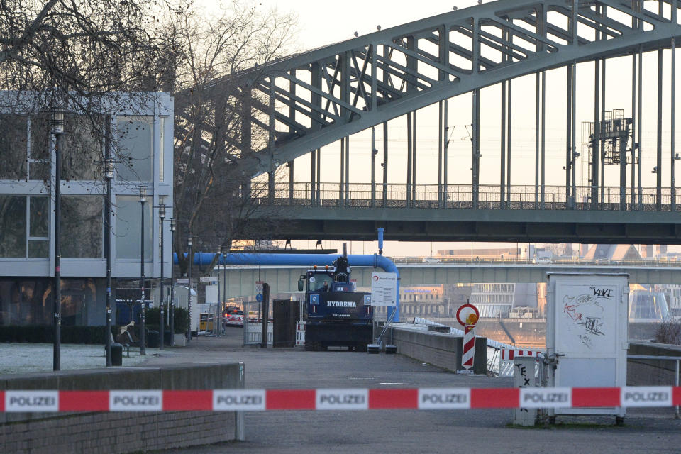 The excavator that uncovered the bomb stands in front of the Hohenzollern Bridge in Cologne, Germany, Tuesday, Jan. 21, 2020. A train station, an opera house and a TV station in the western Germany city of Cologne are evacuated on Tuesday as experts prepare to defuse an American 500-kilogram (1,100-pound) bomb from World War II. (Roberto Pfeil/dpa via AP)