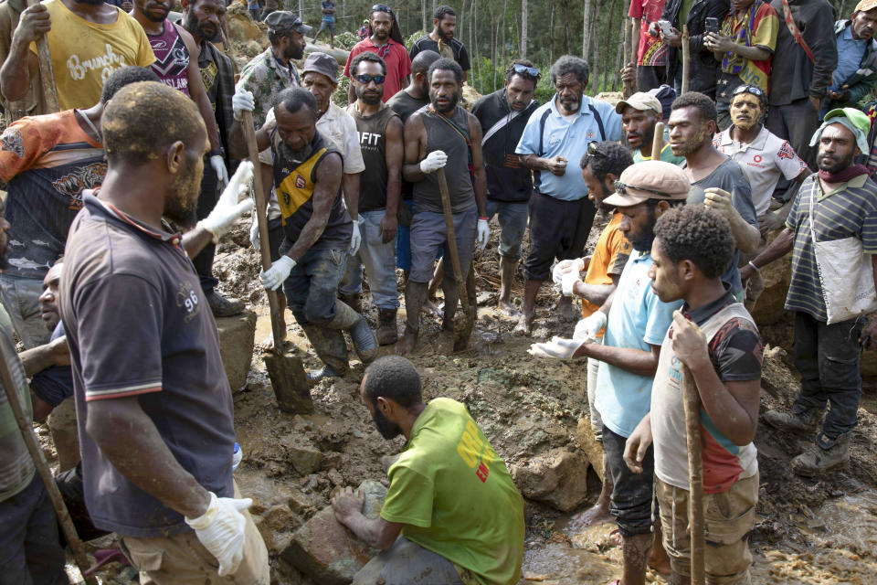 In this photo released by UNDP Papua New Guinea, villagers search through a landslide in Yambali village, in the Highlands of Papua New Guinea, Monday, May 27, 2024. Authorities fear a second landslide and a disease outbreak are looming at the scene of Papua New Guinea's recent mass-casualty disaster because of water streams trapped beneath tons of debris and decaying corpses seeping downhill following the May 24 landslide. (Juho Valta/UNDP Papua New Guinea via AP)