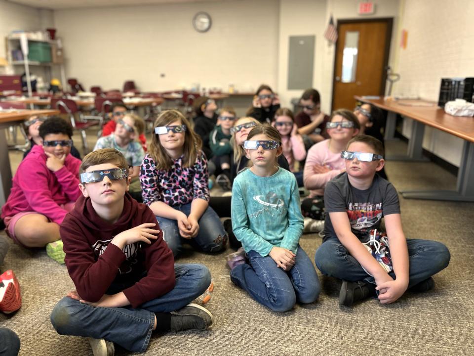 Fourth grade students at Morenci Elementary School practice wearing solar eclipse viewing glasses during a recently held program about the Monday, April 8, 2024, solar eclipse with staff members from the Stair District Library.