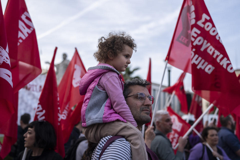 A father with his daughter attend a pre-election rally of a leftist group in Athens, on Monday, May 15, 2023. Greeks go to the polls Sunday, May 21, in the first general election held since the country ended successive international bailout programs and strict surveillance period imposed by European leaders. Conservative Prime Minister Kyriakos Mitsotakis is seeking a second four-year term and is leading in opinions but may need a coalition partner to form the next government. (AP Photo/Petros Giannakouris)