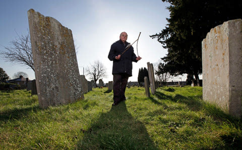 Dowser John Baker, dowsing in his local churchyard at St Paulinus' in Crayford, near Dartford - Credit: Heathcliff O'Malley
