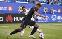 CF Montreal defender Zorhan Bassong controls the ball, moving away from Atlanta United defender Ronald Hernandez during the first half of an MLS soccer match Wednesday, Aug. 4, 2021, in Montreal. (Paul Chiasson/The Canadian Press via AP)