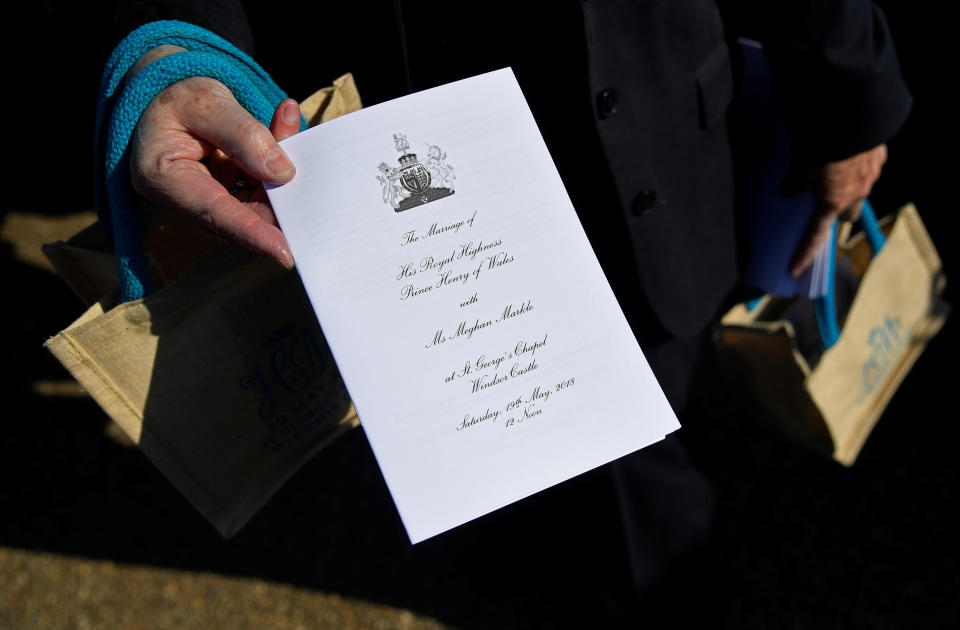 A member of staff holds a service sheet and goodie bags ahead of the wedding of Britain's Prince Harry to Meghan Markle.