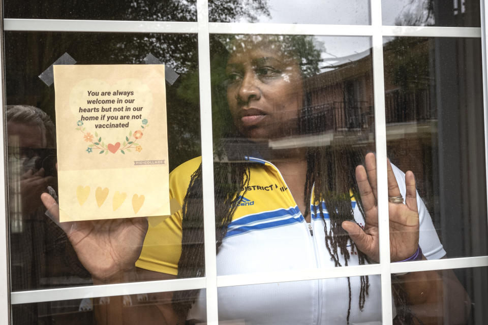 Octavia Tokley, the widow of Erin "Toke" Tokley, a Philadelphia cop who died from COVID-19 in March poses on Aug. 29, 2021, in Secane, Pa. Tokley was scheduled to be vaccinated on March 11 – which turned out to be his funeral. (AP Photo/Laurence Kesterson)