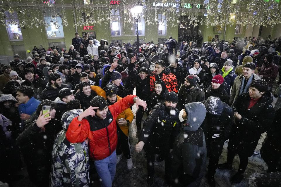 People celebrate the New Year in Nikolskaya street near an empty Red Square due to pandemic restrictions during New Year celebrations in Moscow, Russia, Saturday, Jan. 1, 2022. Russia's state coronavirus task force has registered a total of about 10.5 million confirmed infections and 308,860 deaths, but the state statistics agency that uses broader criteria in its tallying system has reported nearly 626,000 virus-linked deaths in Russia since the start of the pandemic. (AP Photo/Alexander Zemlianichenko Jr)