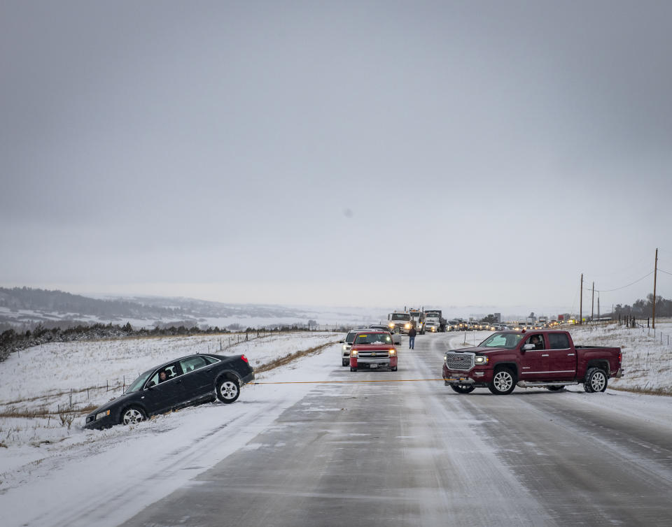 Kary Prince, de Colorado Springs, jala con su camioneta el auto de Valkyrie Ellis en la autopista Colorado Hwy. 83 mientras una fila de autos espera detrás de ellos, el viernes 18 de enero del 2019 en Larkspur, Colorado. (Dougal Brownlie/The Gazette via AP)