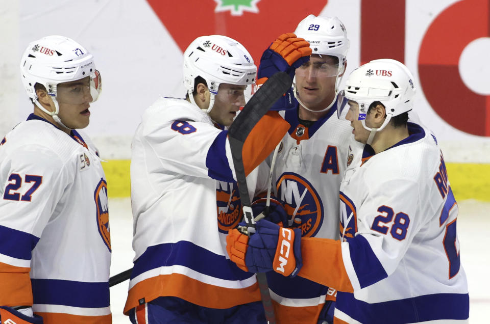 New York Islanders defenseman Noah Dobson (8) celebrates his goal with teammates Anders Lee (27), Brock Nelson (29) and Alexander Romanov (28) during second-period NHL hockey game action against the Ottawa Senators in Ottawa, Ontario, Monday, Nov. 14, 2022. (Patrick Doyle/The Canadian Press via AP)