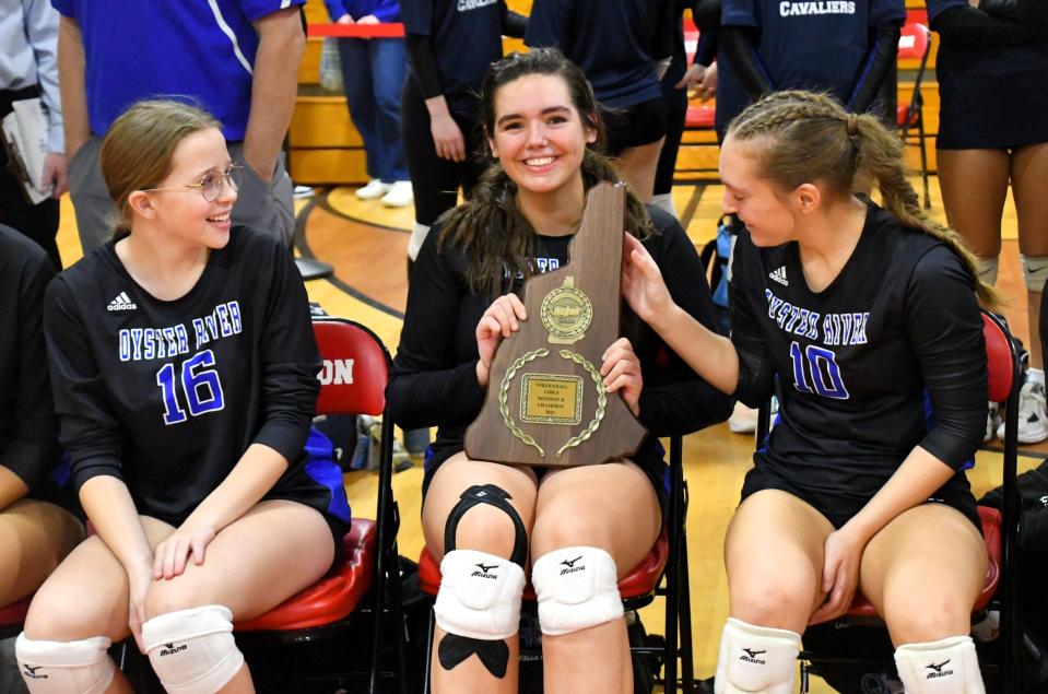 Oyster River senior captain Annabelle Svenson, center, happily displays the Division II championship plaque with teammates Leah Lynskey, left, and Kylie Dulac. Svenson was named the New Hampshire Volleyball Coaches Association Division II Player of the Year.