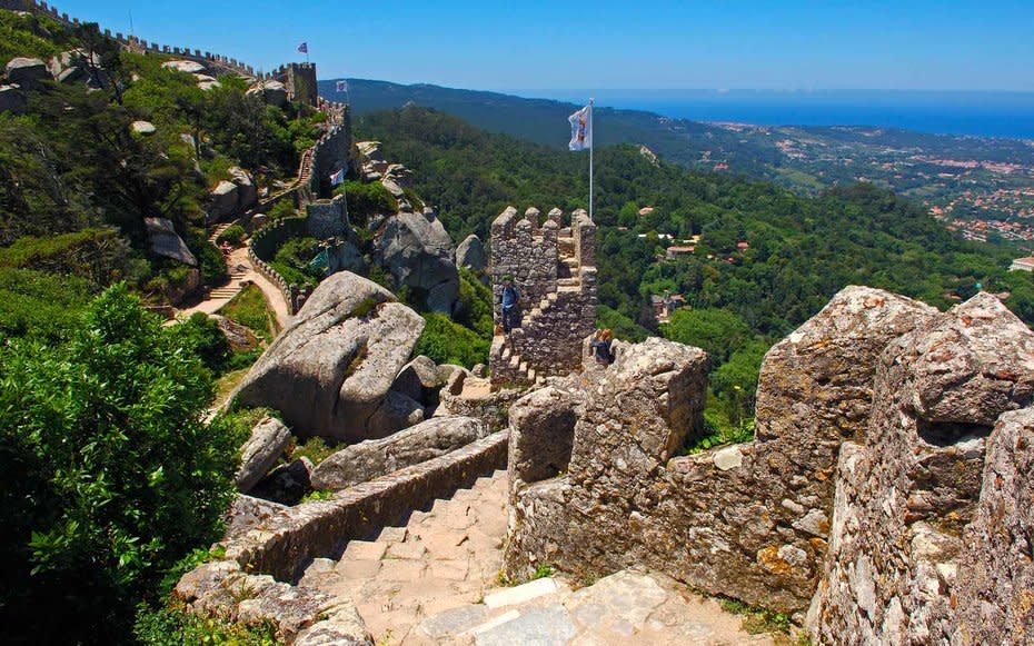 <p>You cant go far in Sintra without spotting a ruin or castle wall of some sort. The hilly area is spotted with royal palaces and castles, one of those being Castelo dos Mouros. Built in the 10<sup>th</sup> century, these ruins span across mountain ridges providing stunning views of the cities below. <a rel="nofollow noopener" href="https://www.lonelyplanet.com/portugal/sintra/attractions/castelo-dos-mouros/a/poi-sig/477430/360369" target="_blank" data-ylk="slk:Lonely Planet;elm:context_link;itc:0;sec:content-canvas" class="link ">Lonely Planet</a> shares that the best way to access this castle (that is, if youre looking for a moody walk with views) is along Rua Marechal Saldanha, as opposed to the easier-to-find main road.</p>