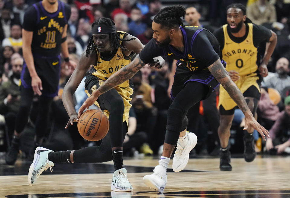 Toronto Raptors forward Mouhamadou Gueye, left, steals the ball from Los Angeles Lakers guard D'Angelo Russell (1) during the first half of an NBA basketball game Tuesday, April 2, 2024, in Toronto. (Frank Gunn/The Canadian Press via AP)