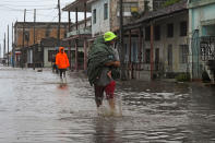 <p>People walk through the flooded streets of Batabano, Cuba, on Sept. 27. <a href="https://people.com/human-interest/hurricane-ian-strengthens-evacuations-begin-tampa-prepares-direct-hit/" rel="nofollow noopener" target="_blank" data-ylk="slk:Ian made landfall there on Sept. 27;elm:context_link;itc:0;sec:content-canvas" class="link ">Ian made landfall there on Sept. 27</a> as a category 3 storm, knocking out the country's electrical grid. </p>