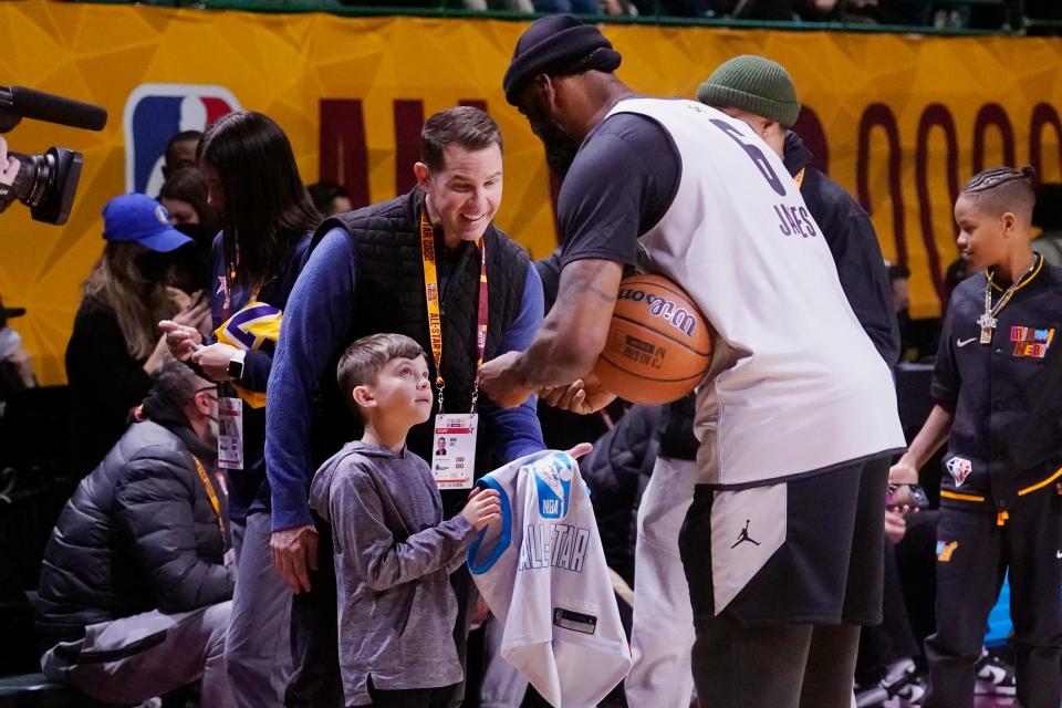 Los Angeles Lakers forward LeBron James signs an autograph for a fan during a practice session for the NBA All-Star game in Cleveland, Saturday, Feb. 19, 2022. (AP Photo/Charles Krupa)