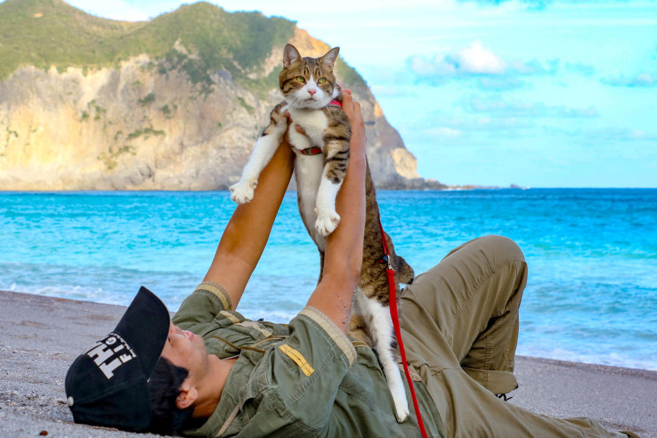 <p>Daisuke Nagasawa hold up his cat Daikichi on a beautiful Japanese beach. (Photo: Daisuke Nagasawa/Caters News) </p>